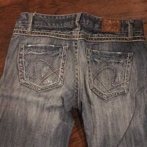 BKE slightly distressed faded wash boot cut jeans.